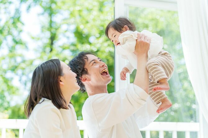 赤ちゃんとくつろぐ若い親