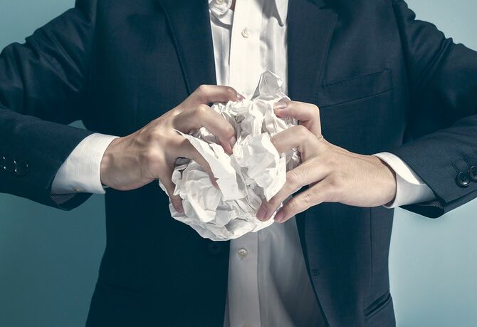 古紙をぐしゃぐしゃに丸めるアジアの実業家