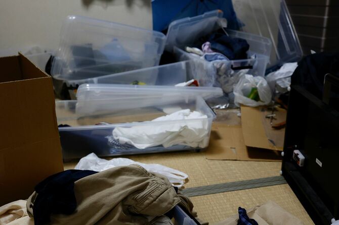 服や未使用品がたくさんある汚れた部屋。
