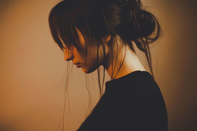 うつむく髪の乱れた女性