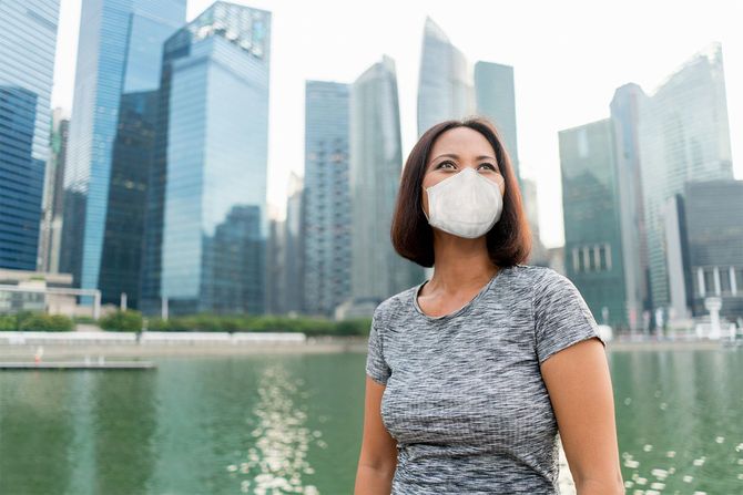 COVID-19を避けるためにフェイスマスクを着用したシンガポールのビジネスウーマン