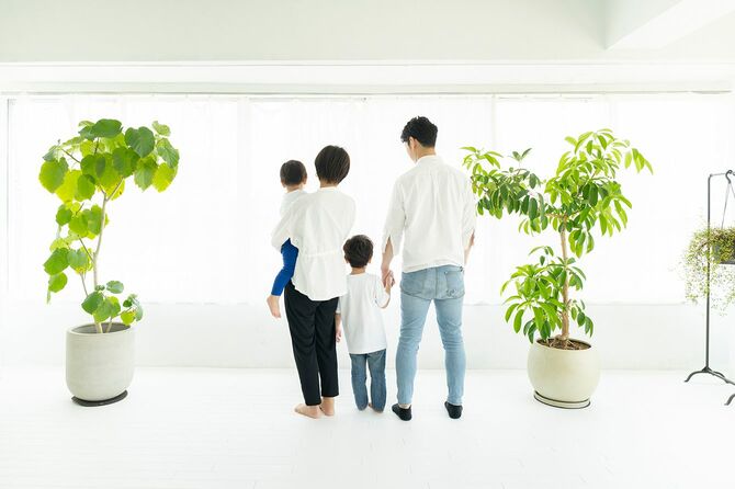 窓のそばに並んで立っている家族