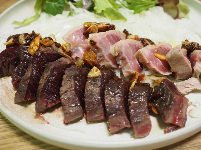 手前が血合いのニンニクレアステーキ。奥がスジの多い赤身のステーキ。バラ色の食卓！