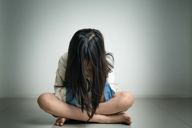 一人で怖い、悲しいうつ病の子供たちはいじめられた後、暗い部屋で彼女の顔を閉じます