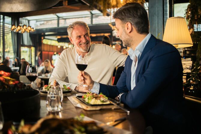 ランチでくつろぎながら話す2人のビジネスマン