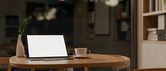 木製テーブルの上に置かれたキーボード付きタブレット端末