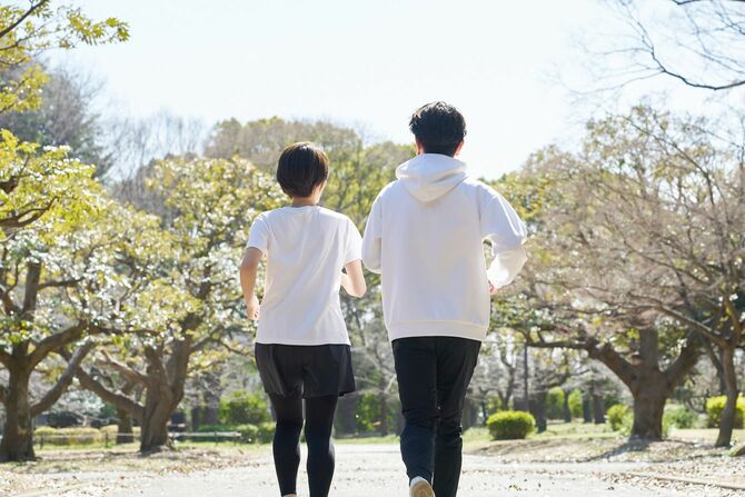 屋外で並んで走る男女