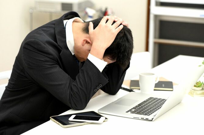 頭を抱えて嘆いている男性