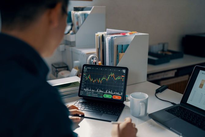タブレットで株価チャートをチェックする男性
