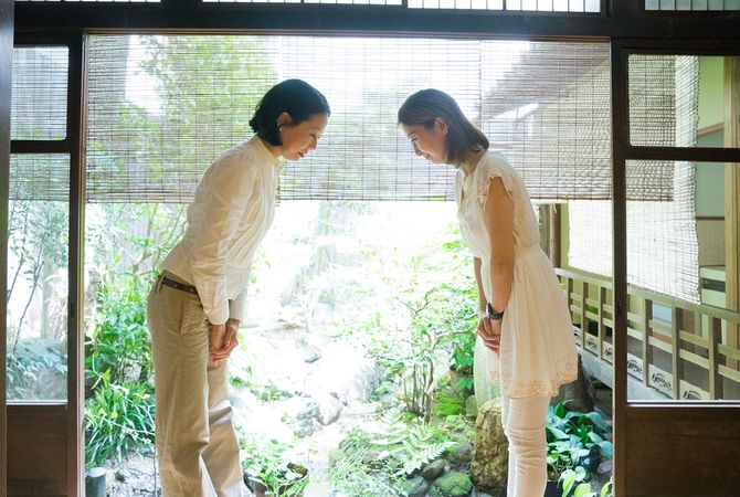 2つの日本女性にお辞儀を尊重した伝統的なホテル