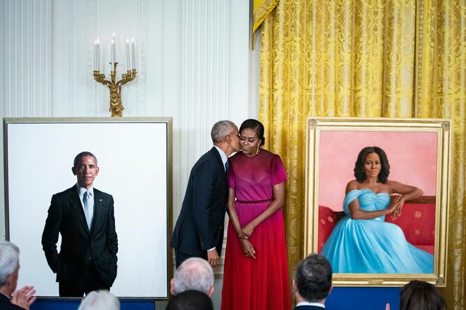 ホワイトハウス公式肖像画の除幕式で、ミシェル・オバマ前大統領夫人にキスをするバラク・オバマ前米大統領（中央左）。（＝2022年9月7日、米ワシントンD.C）
