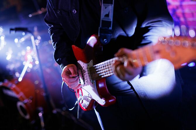 コンサート中にエレキギターを弾くギタリスト