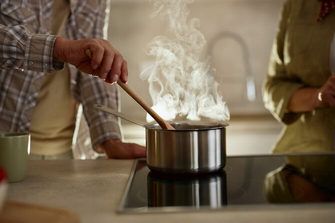 キッチンでスープを作っているカップル