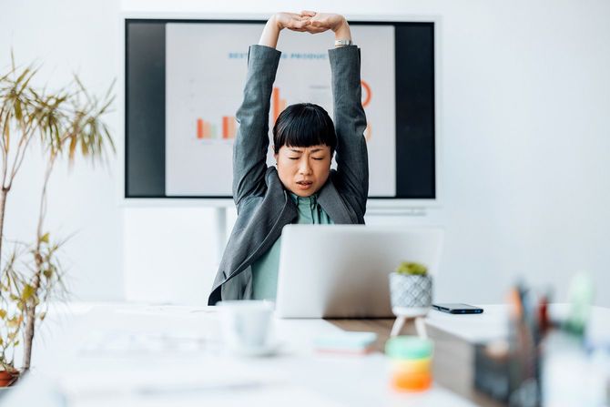 両手を上げて伸びをする女性