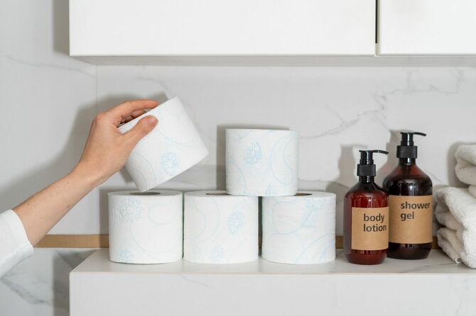 ストックのトイレットペーパーをひとつ手にする女性