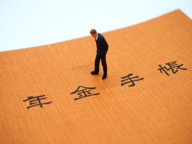 年金手帳とミニチュアの人形