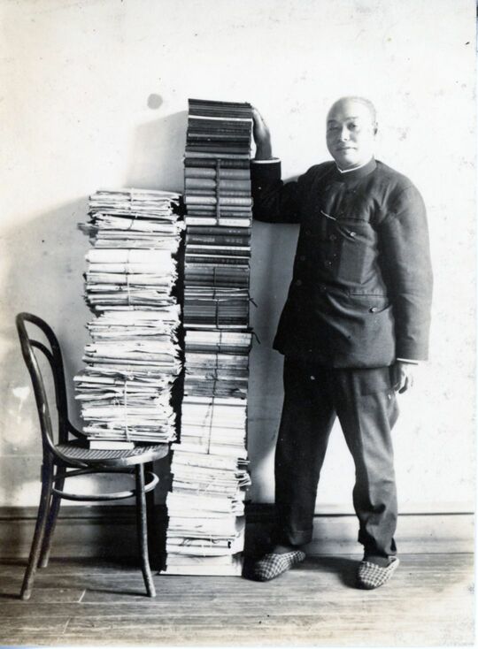 山積みの著作に手を添える本多静六。生涯で370冊もの自著を残した。