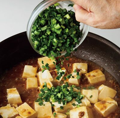 3分煮てにら、ごま油を入れて全体を混ぜる