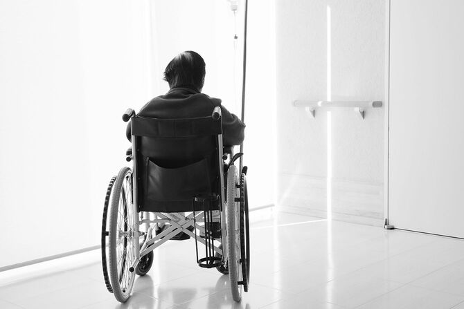 病院で車椅子に座っている先輩または高齢女性のバックビュー
