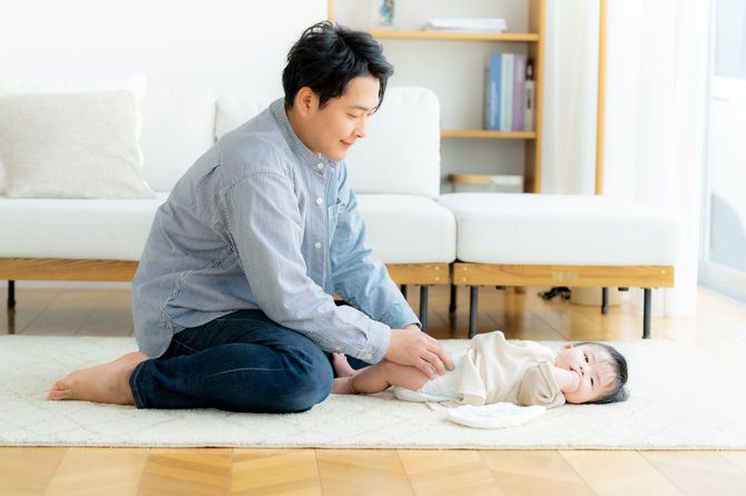赤ちゃんのおむつを交換するお父さん