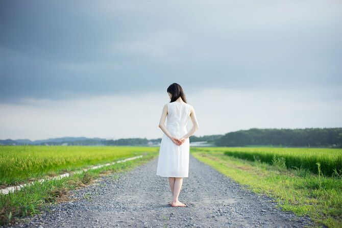 田園風景の中に立つ女性