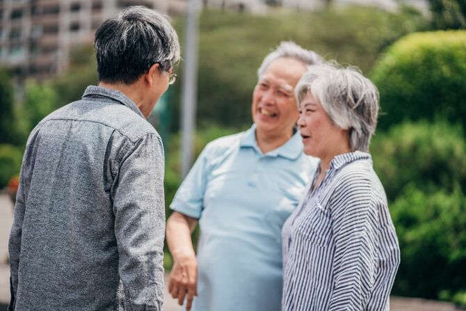 成熟した息子と公園に立っているシニアカップル