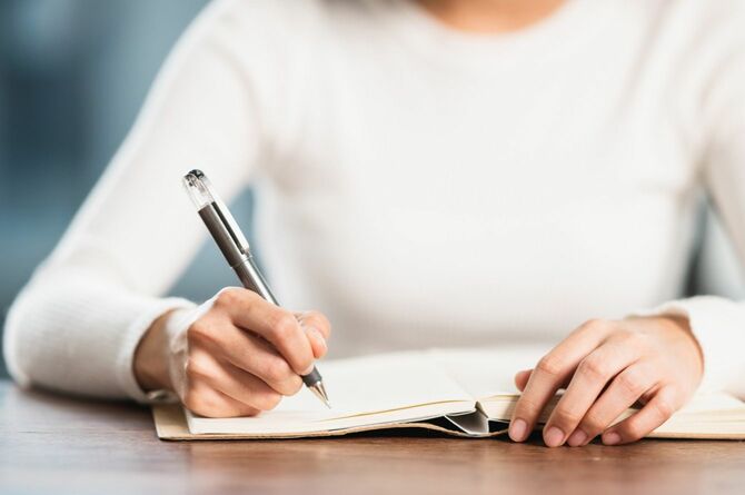 ノートに記述する女性