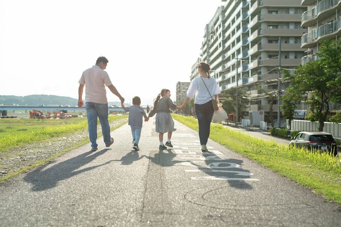 土手を歩く仲の良い家族