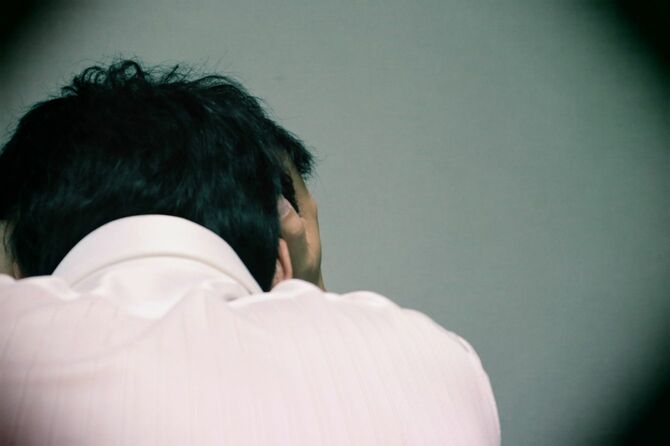 うずくまって頭を抱えている男性