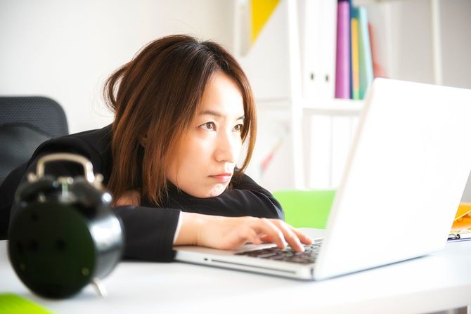 ノートパソコンの画面を眺める女性