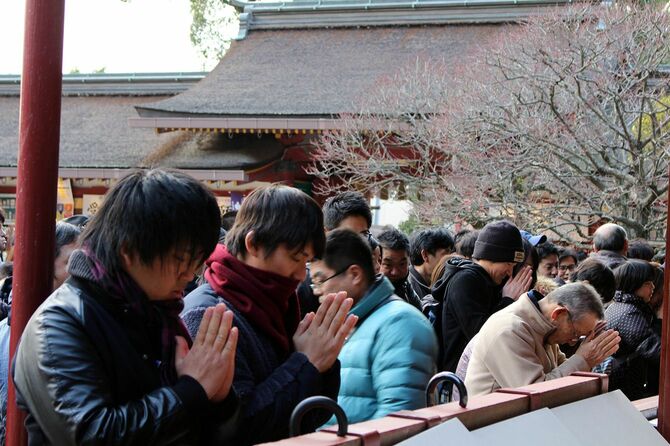 神社でお参りをする人々