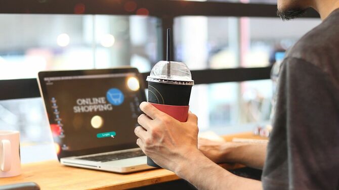 コーヒーを飲みながらパソコンを操作する人