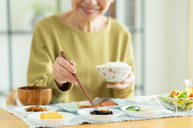 朝食を食べる老人女性